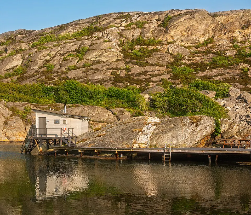 Sauna ved stille vand i aftenlys